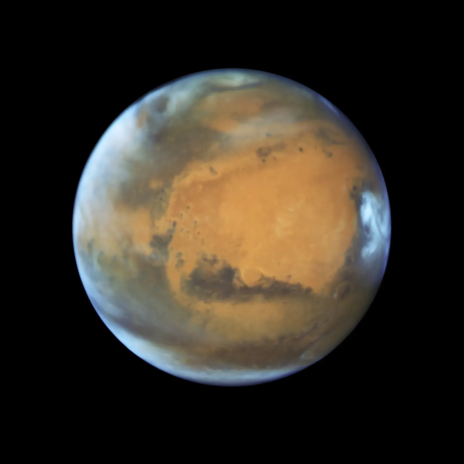 Reference image of Mars from Hubble in 2016 showing the reddish disk with the polar cap and darker surface features